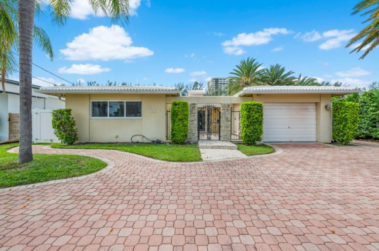 This charming home offers a gated entrance, a spacious circular driveway, and lush landscaping, all just minutes from the beach and city conveniences—perfect for privacy and comfort.